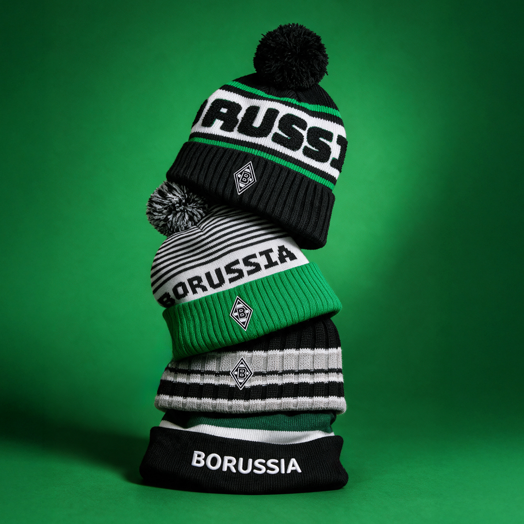 A stack of four Borussia-themed beanies in green, black, and white, with varying patterns, against a green background.