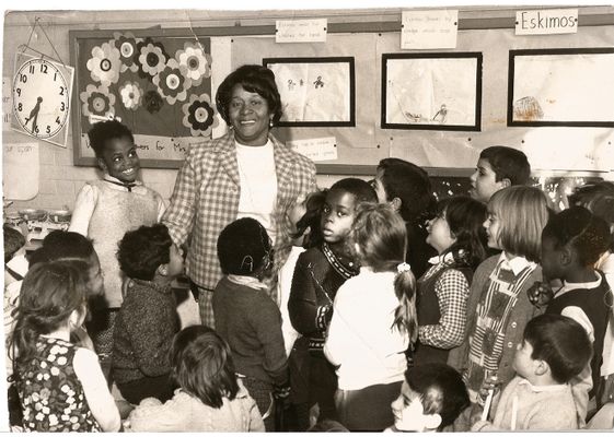 Black and white image of Beryl Gilroy and pupils in a classroom