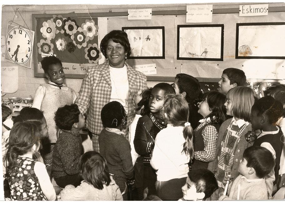 Black and white image of Beryl Gilroy and pupils in a classroom