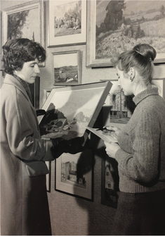 Black and White photo of a library member negotiating a Picture Loan with a librarian