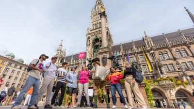 EF Language Abroad students gathered in Marienplatz in Munich, listening to a street musician playing the accordion in front of the historic Neues Rathaus.