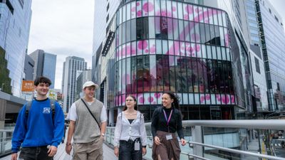 EF Language Abroad students walking together through Shibuya in Tokyo, surrounded by modern glass buildings and city streets.