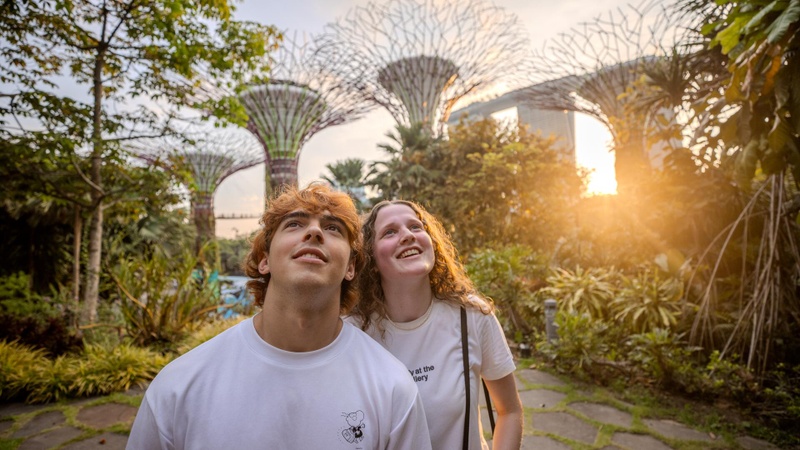 Two EF Language Abroad students enjoying Gardens by the Bay in Singapore, looking up at the Supertrees while exploring the city during sunset.