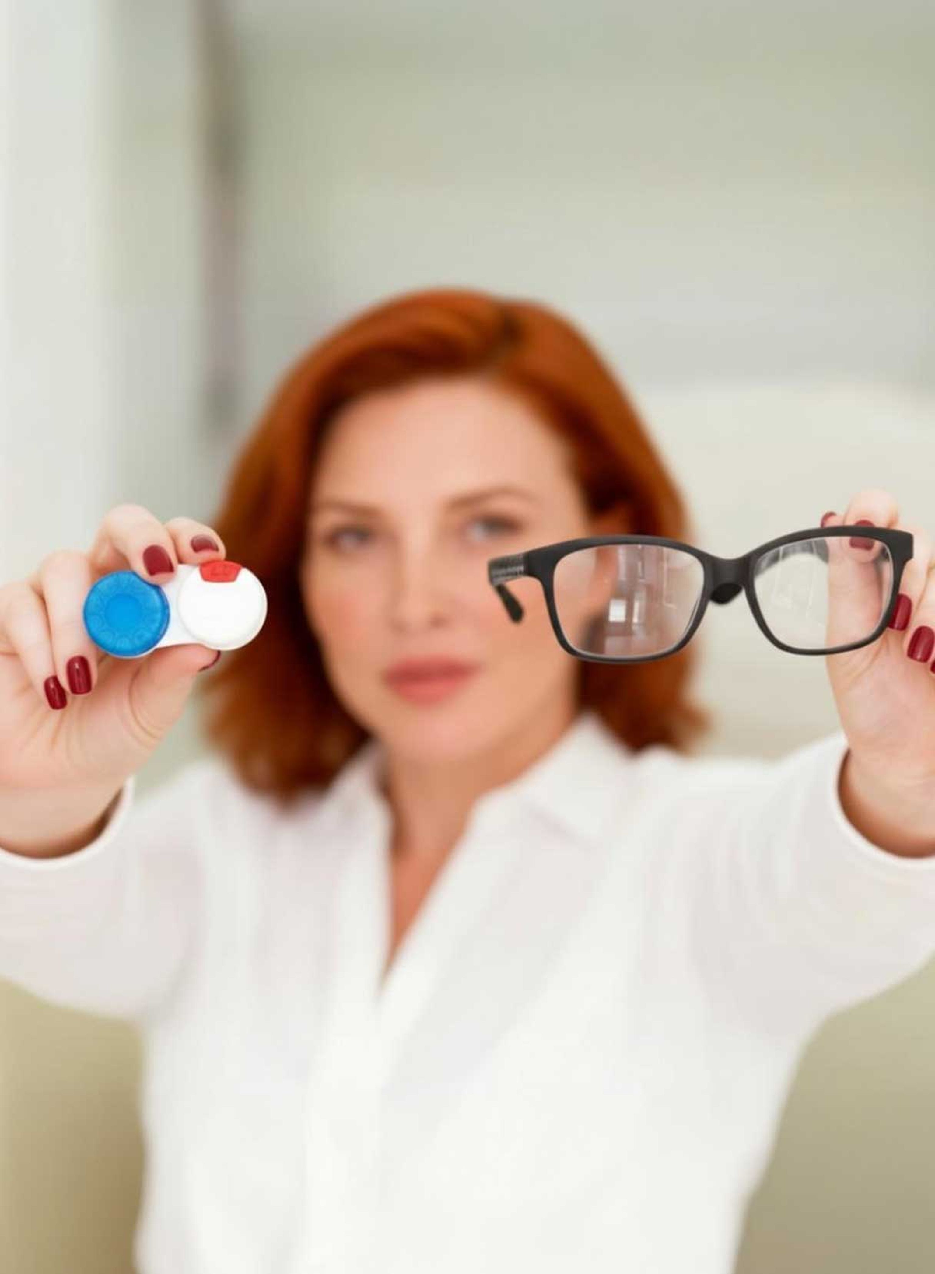 Donna con capelli rossi elimina occhiali e lenti a contatto dopo intervento laser agli occhi