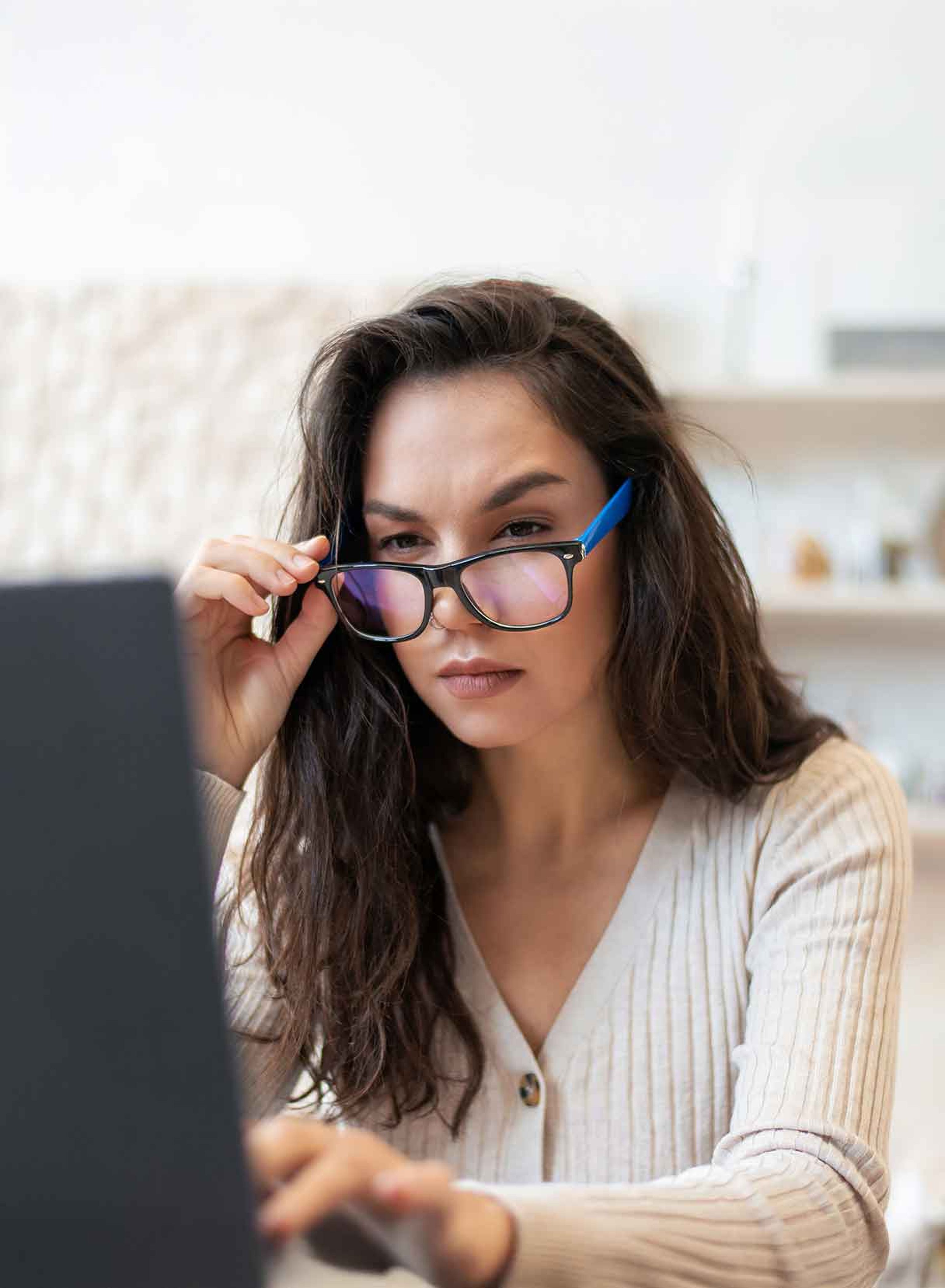 persona miope sposta gli occhiali davanti allo schermo di un computer portatile