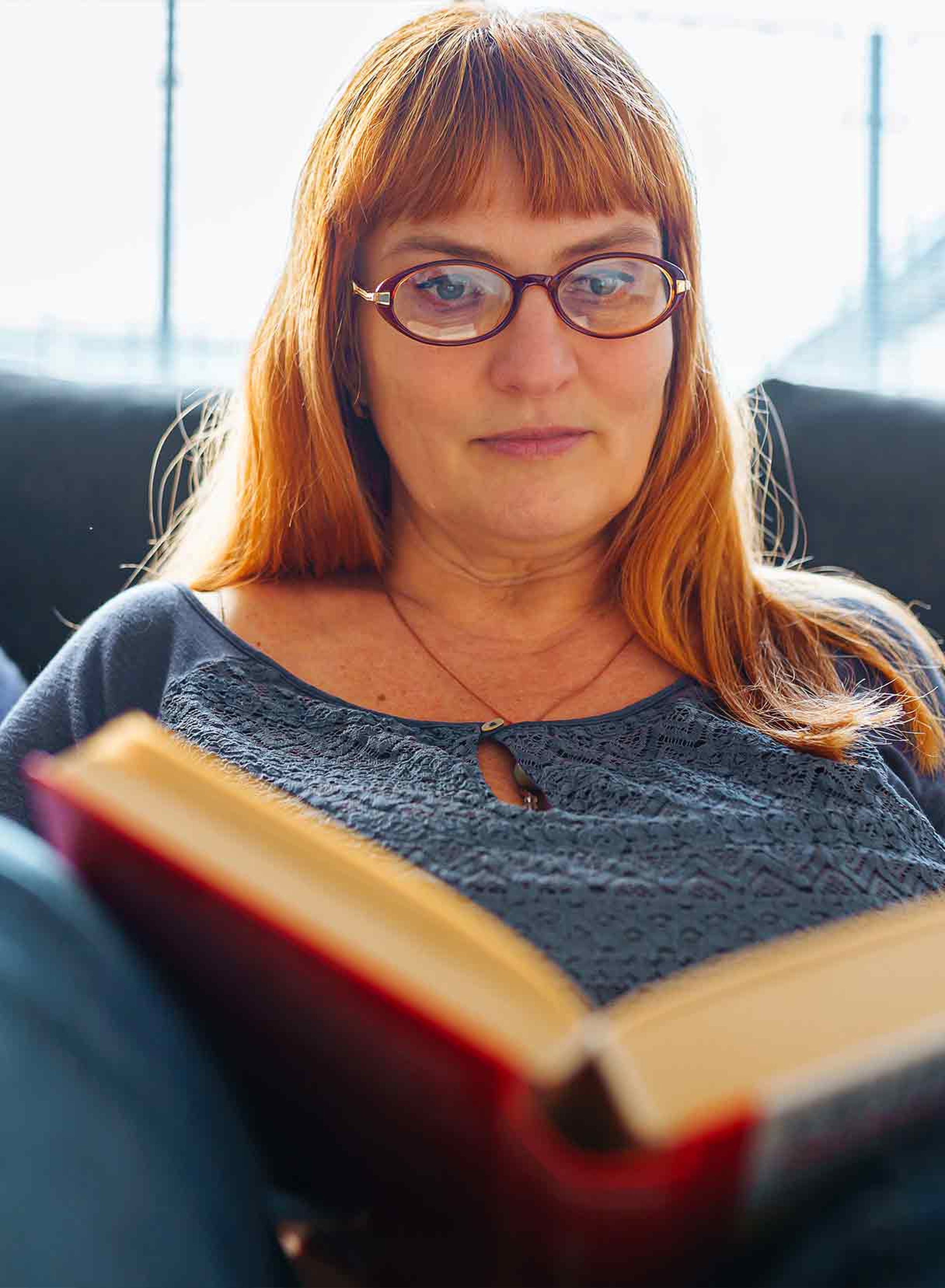 donna legge un libro con occhiali di lettura per la presbiopia