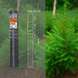 A roll of fencing material labeled "Forst," with measurements, is displayed beside a lush green conifer tree in a forest setting.