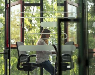Person sits in headset in front of their laptop