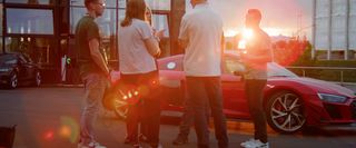 Group of people standing in front of a audi