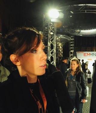 Zwei Personen in Konferenzausweise im Gespräch auf einer Technologie-Veranstaltung bei professioneller Beleuchtung