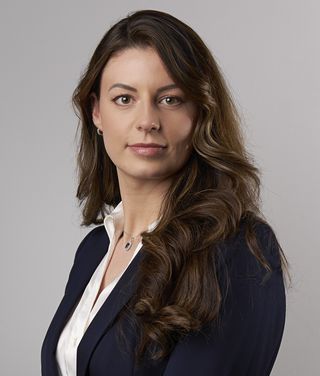 Isabella Narius im Businessporträt vor grauem Hintergrund