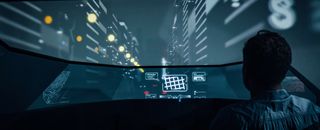 person sits in a futuristic car at night