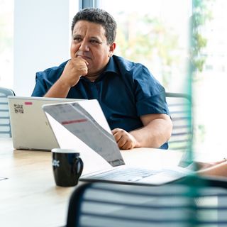 person sits in the conference room at the computer and thinks