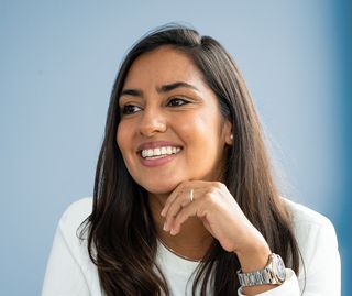 person sits smiling at the desk
