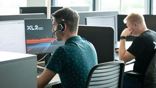 two people sit at their desks and work