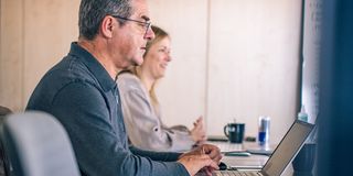 UX/UI-Team in einer Besprechung mit Whiteboard und Laptops