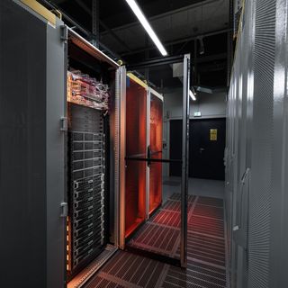Moderner Datencenter-Serverraum mit roten Kühleinheiten und metallischen Serverracks