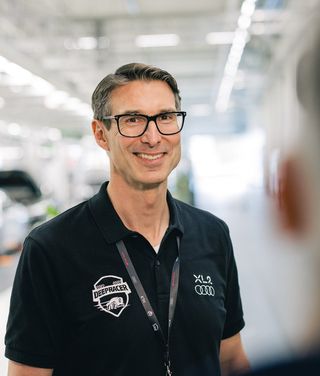 Group of professionals standing in a modern office space during XL2 company meeting