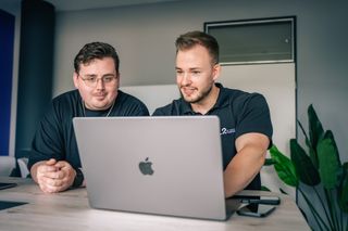 MacBook Pro mit Management-Summary-Anwendung auf dem Bildschirm in einem Büroumfeld