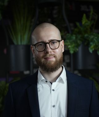 Dr. Thomas Kittler vor einem begrünten Hintergrund