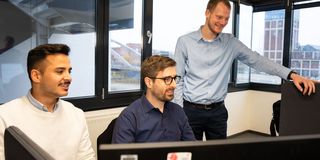 Mitarbeiter blicken gemeinsam auf Monitor