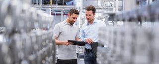 two people talking in the production hall