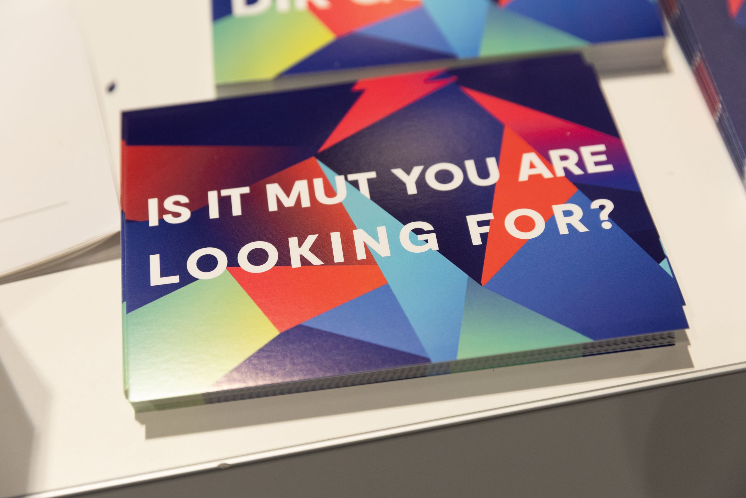 Colorful card with geometric shapes and the text "IS IT MUT YOU ARE LOOKING FOR?" on a white surface.