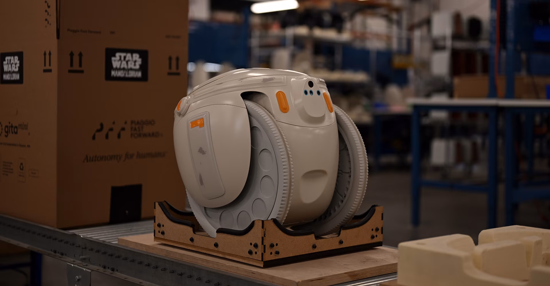 Behind the scenes image showing Grogu gitamini in the factory with Star Wars packing.