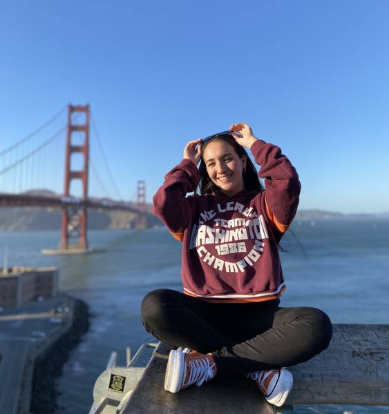 Girl sitting infront of a bridge in San Francisco.