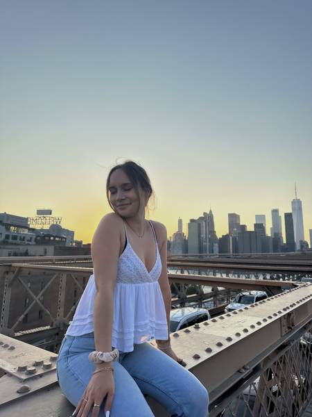 Girl sitting on the Brooklyn Bridge in New York City.