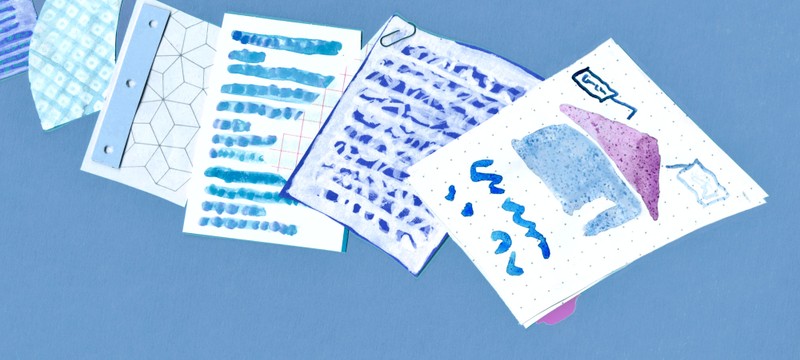 Artistic illustration of scattered papers with abstract blue and purple sketches, text, and geometric patterns on a blue background
