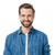 Smiling man with short hair and a beard, wearing a blue denim shirt over a white T-shirt, isolated on a white background.