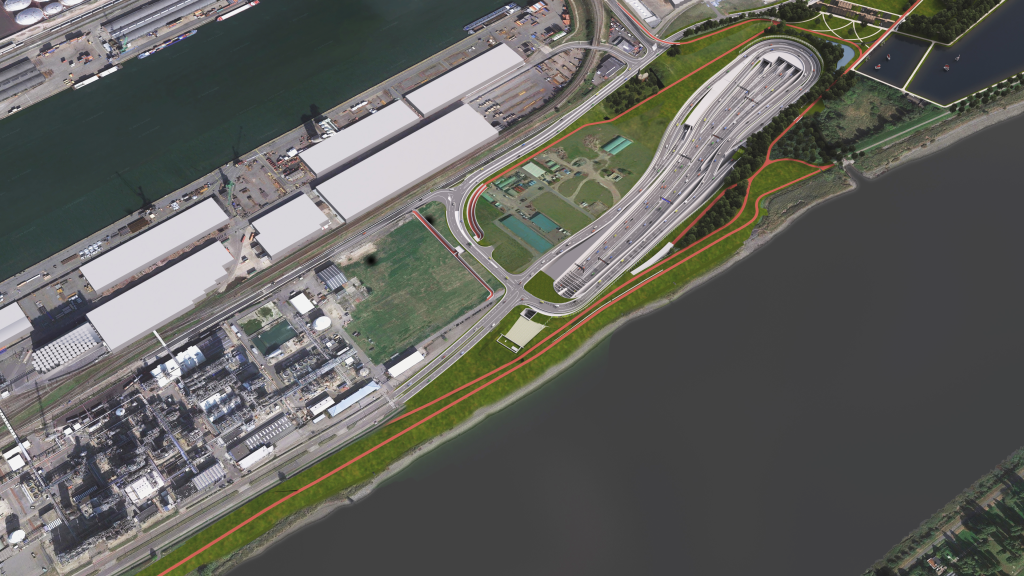 Aerial view of a waterfront area with industrial buildings, roads, greenery, and a large curved bridge near the water's edge.