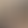 Smiling person with long hair in a black shirt, standing in a modern office setting with blurred background.