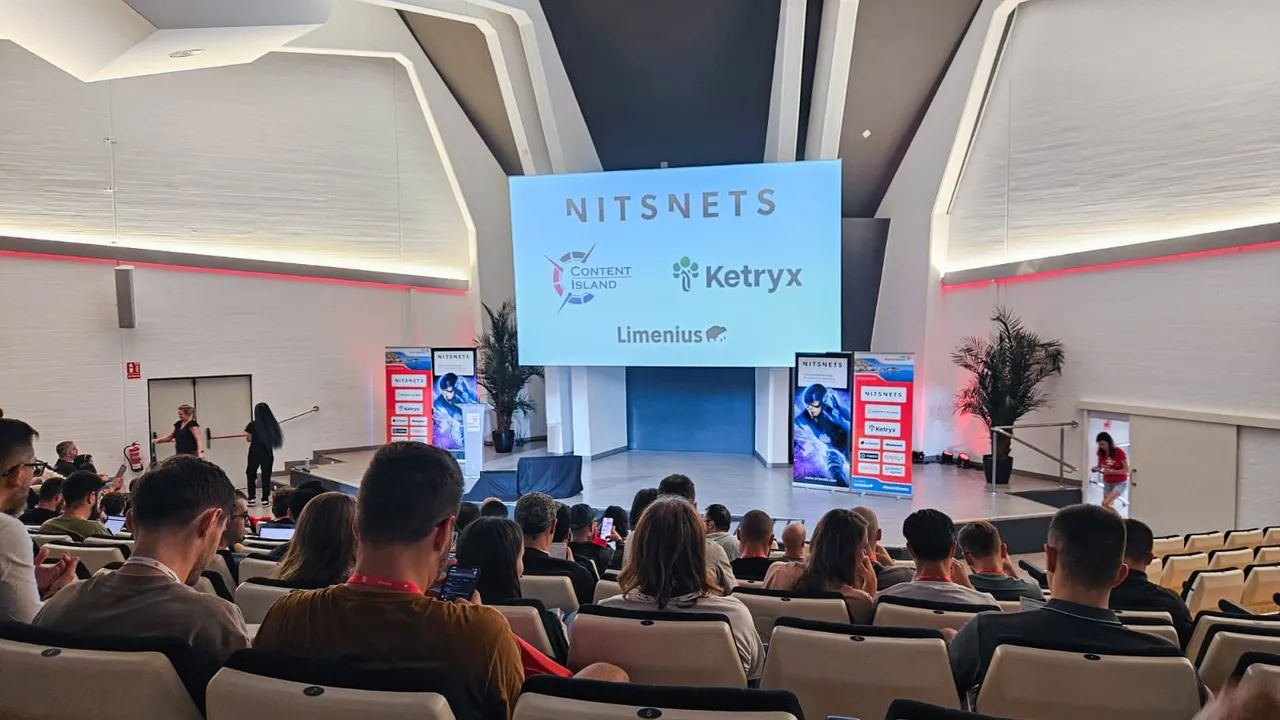 een zaal met allemaal mensen die kijken naar een presentatie