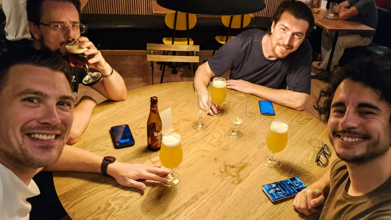 vier mannen die lachen naar de camera en wat drinken in een restaurant