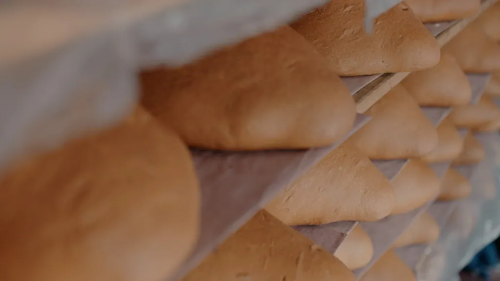 Freshly baked bread cooling on wooden shelves