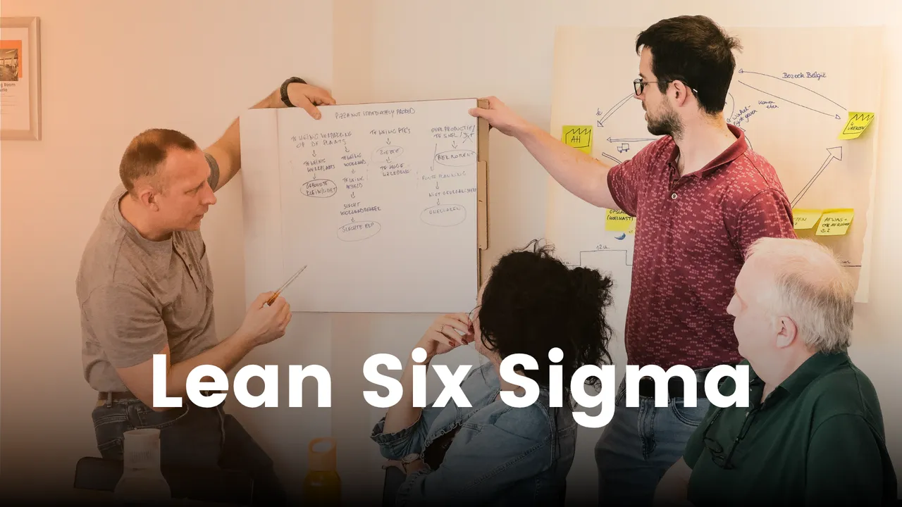 Four people discussing a Lean Six Sigma diagram on a whiteboard, with one person pointing at it, in a collaborative setting.