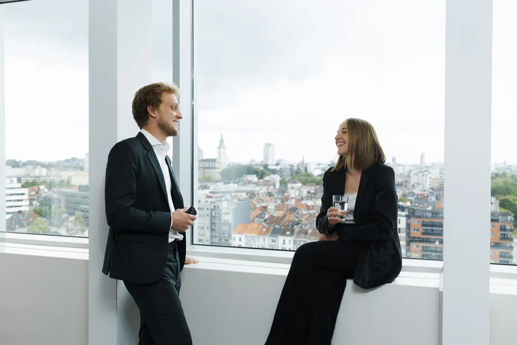 Two colleagues sitting and talking in Ghent office.