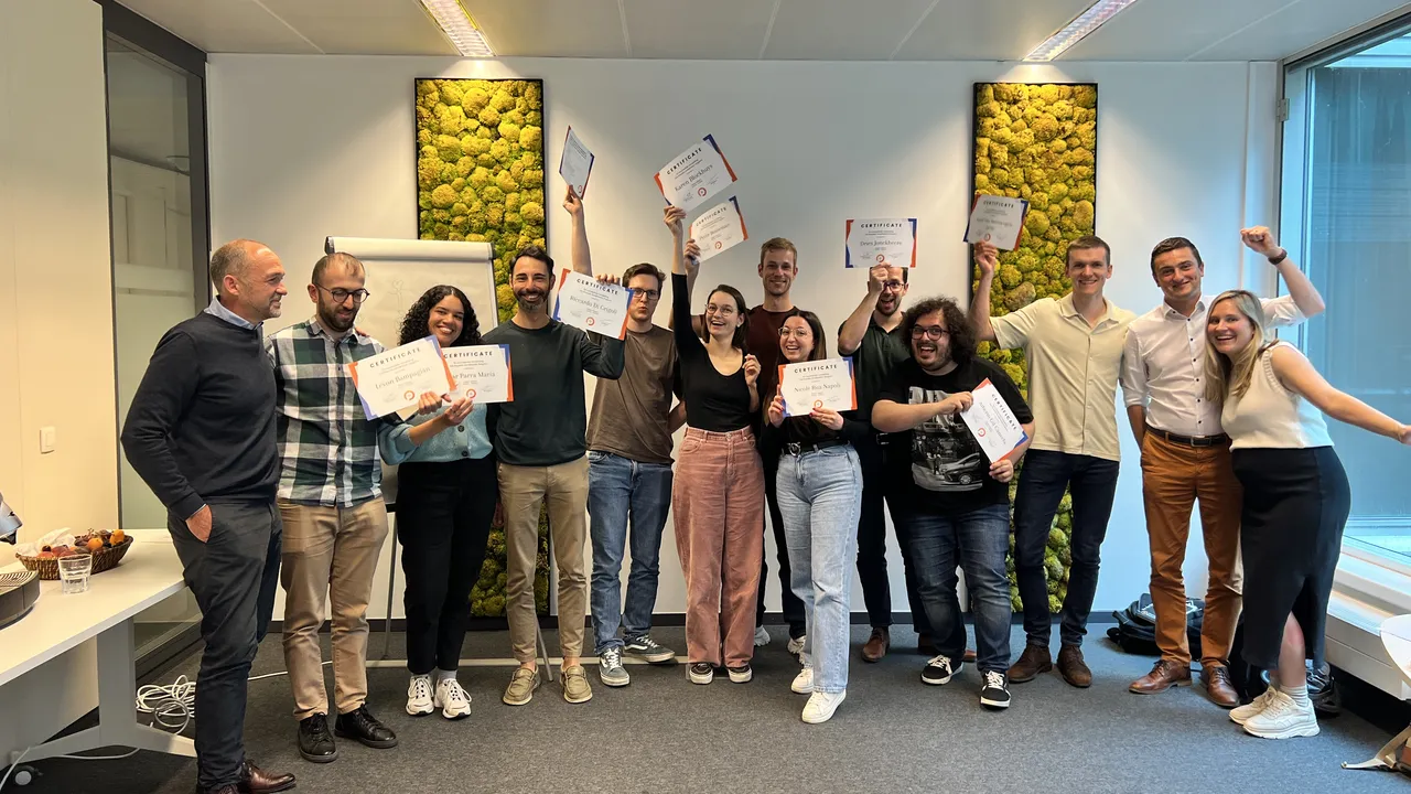 A group of individuals proudly displaying their certificates in a professional office setting.