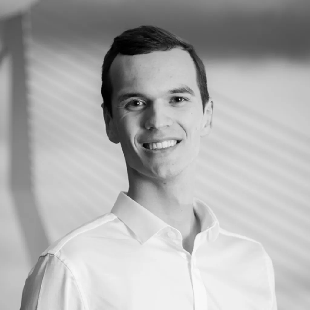 Black and white picture with a man smiling in a white blouse