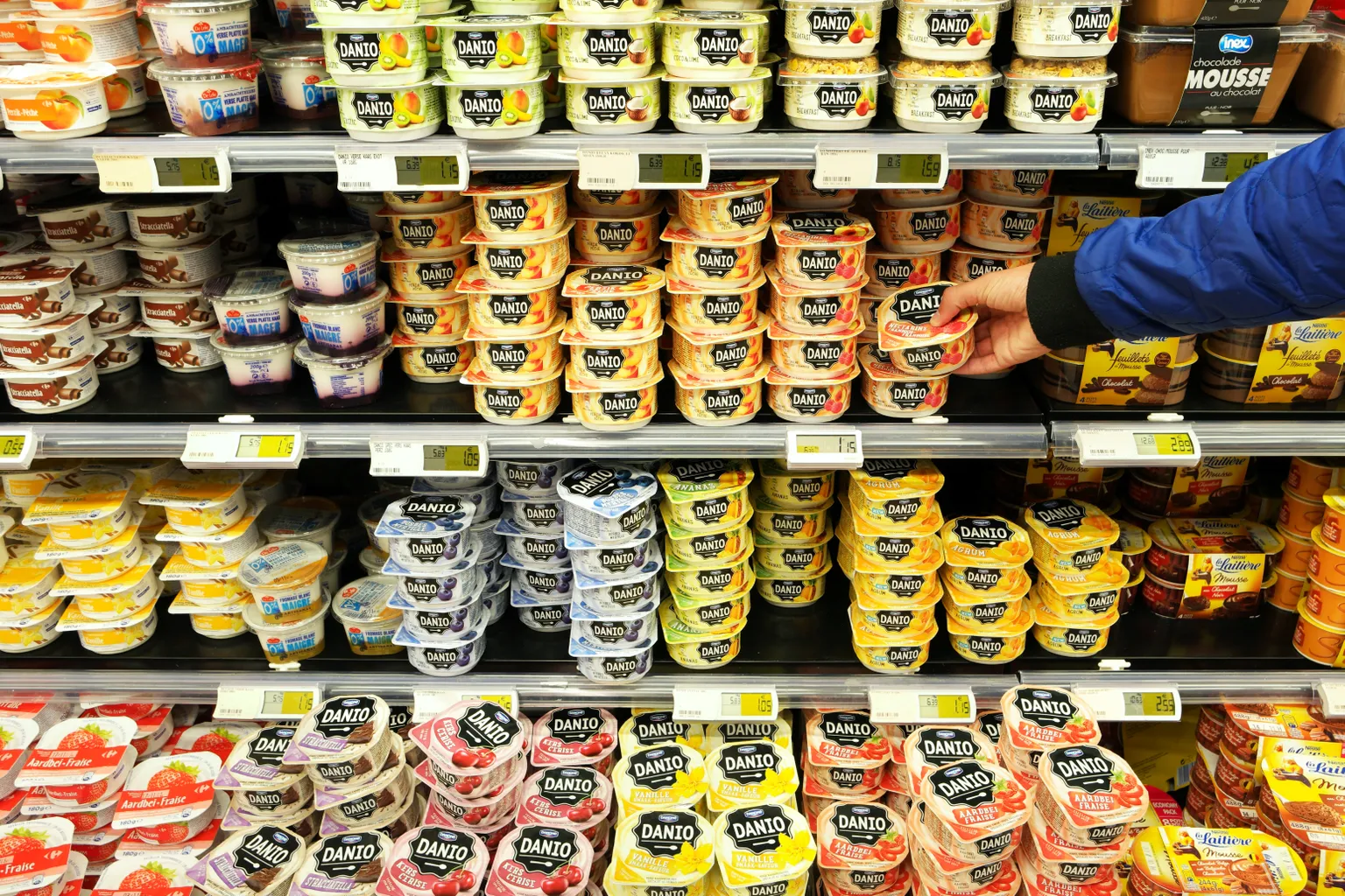 FLANDERS, BELGIUM - OCTOBER 20, 2016: Fresh dairy products of Danio a Danone brand in cooler with desserts of a Carrefour Hypermarket.