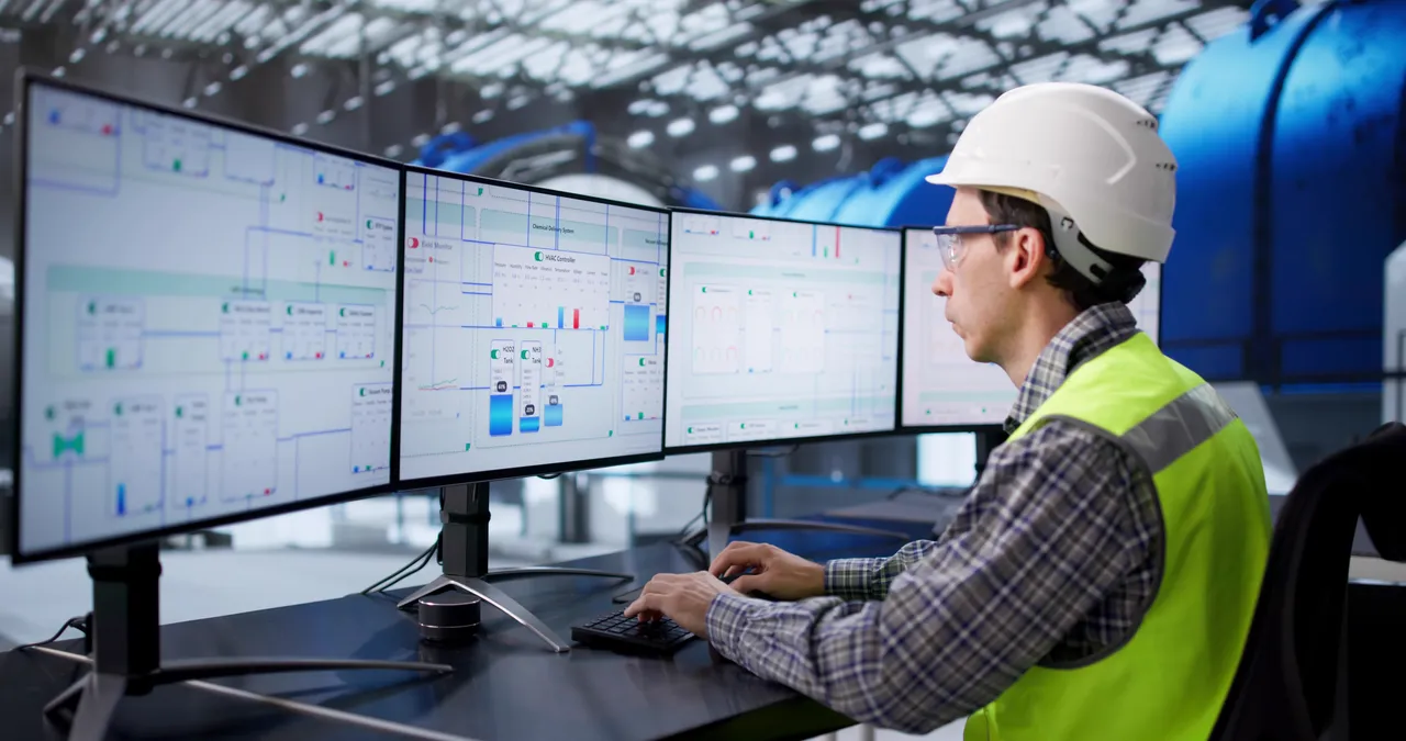 Engineer Monitoring Gas Power Plant Control Room, Checking Multiple Screens.
