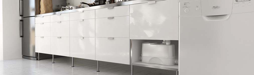 Moderne keuken met strakke witte kasten, roestvrijstalen werkblad en apparatuur. Een Sanibroyeur keuken staat opgeborgen in een open kastruimte.