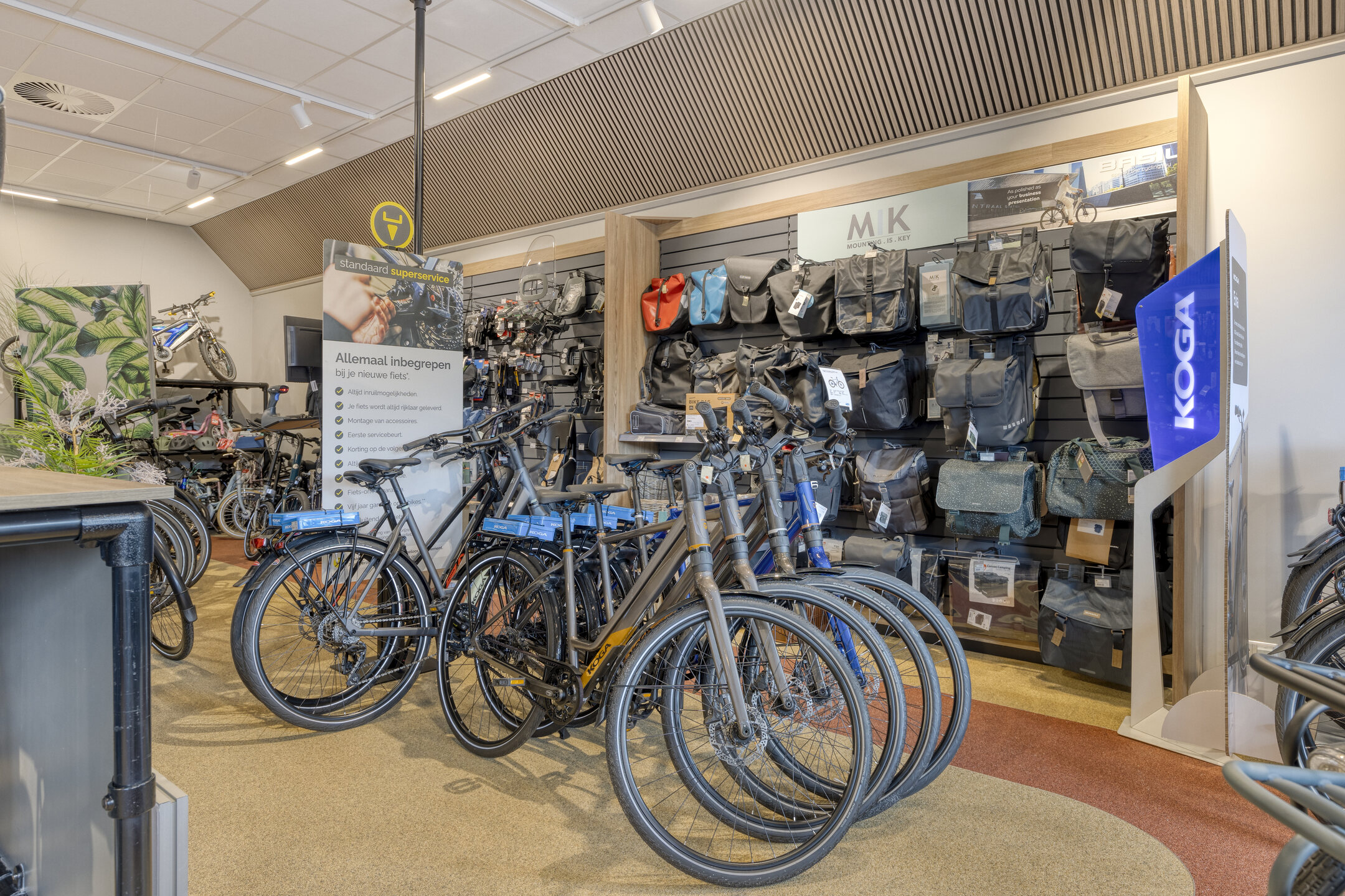 Binnenkant Bike Totaal Thijs Brand Zoetermeer met een assortiment aan stadsfietsen en op de achtergrond een rek met tassen