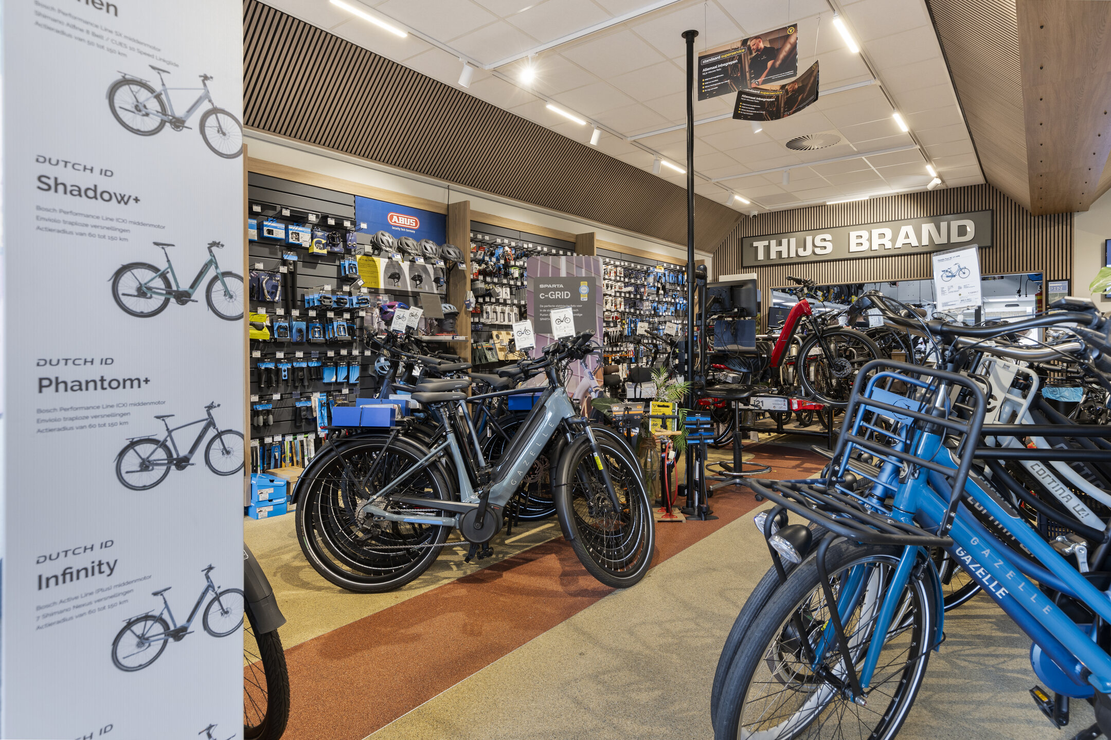 Binnenkant Bike Totaal Thijs Brand Zoetermeer met stadsfietsen aan beide kanten van het gangpad en op de achtergrond een rek met onderdelen en accessoire