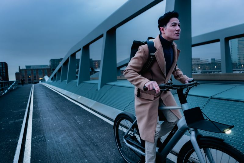 Man op de fiets in de avond over een brug