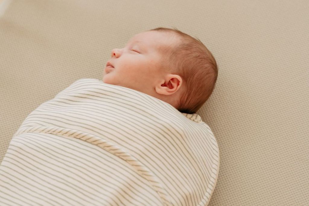 Baby slapend in een slaapzak zonder dekbed