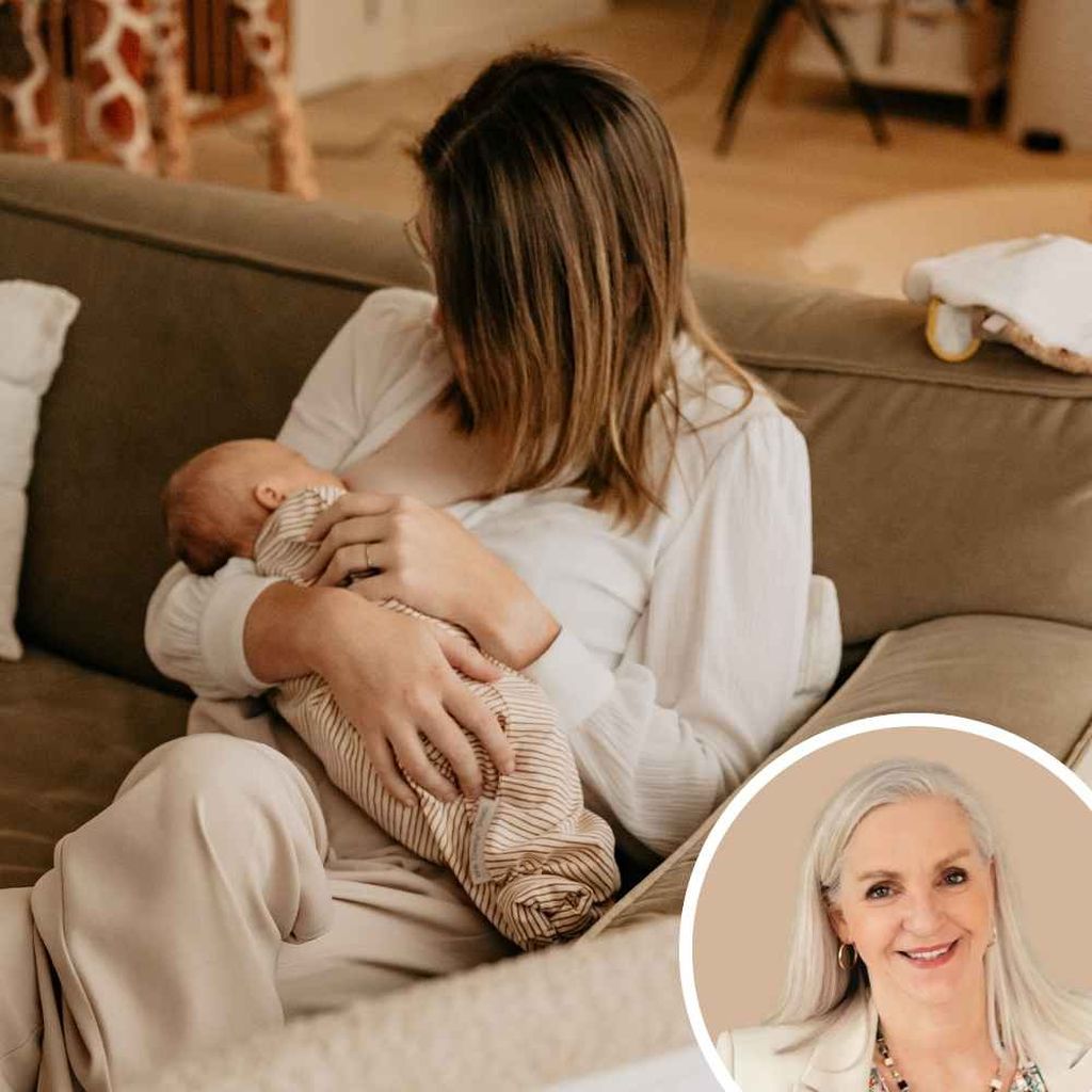 A woman sitting on a couch holds and looks at a baby in her arms.