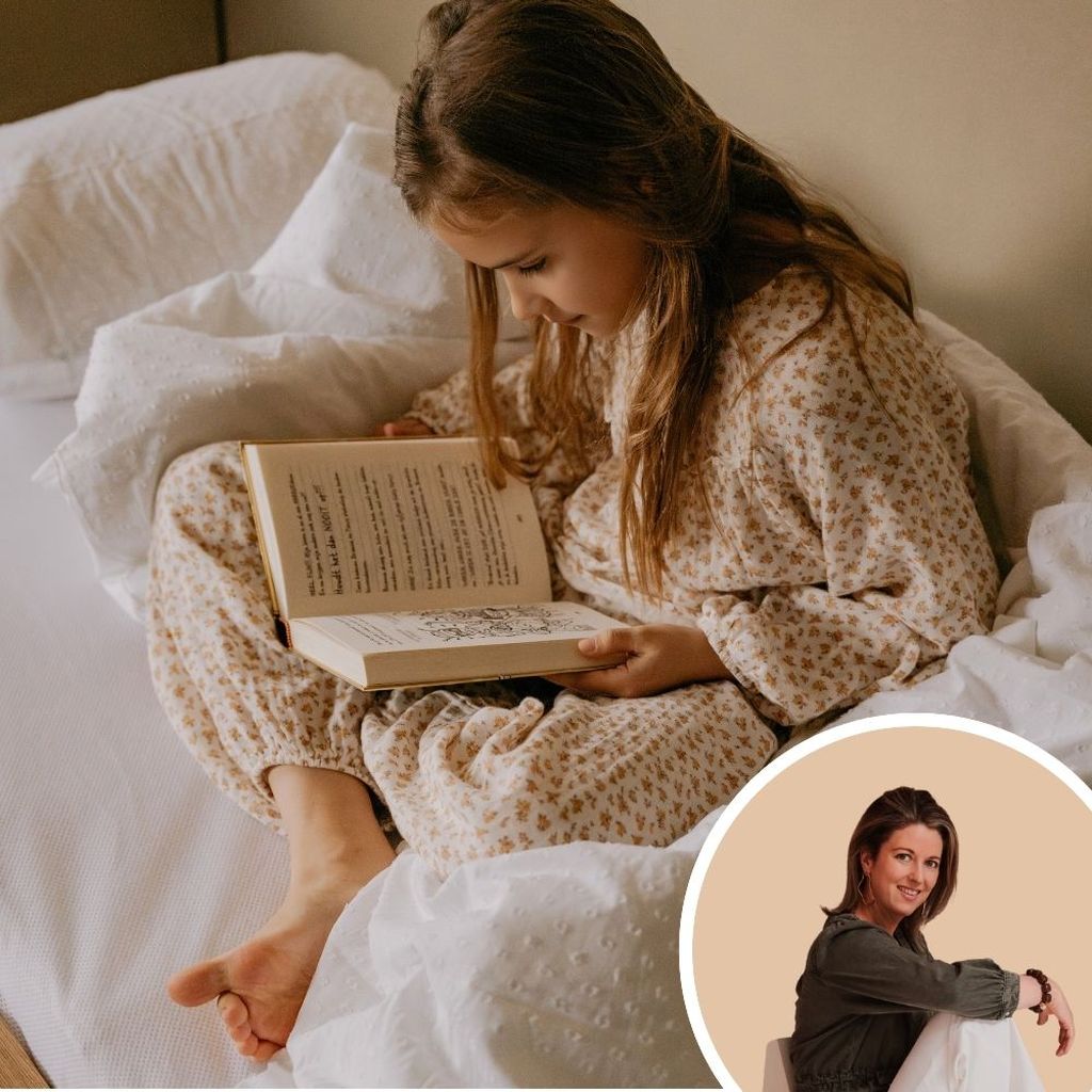 A young girl in floral pajamas reads a book in bed